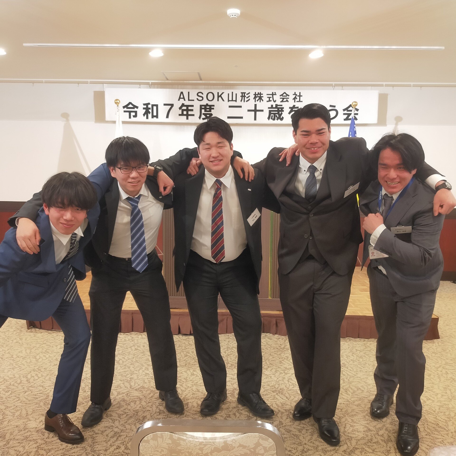 男性が肩を組んでいる写真