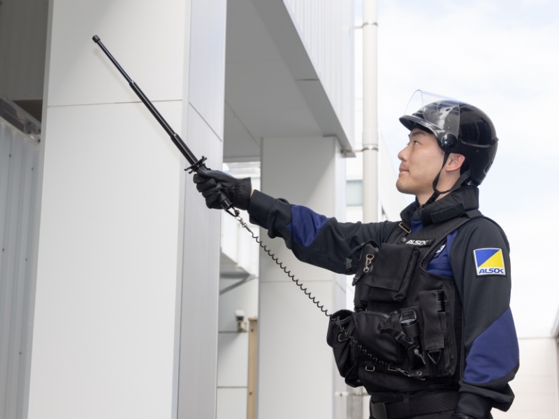 ALSOKガードマンがシャッターを開けようとしている写真