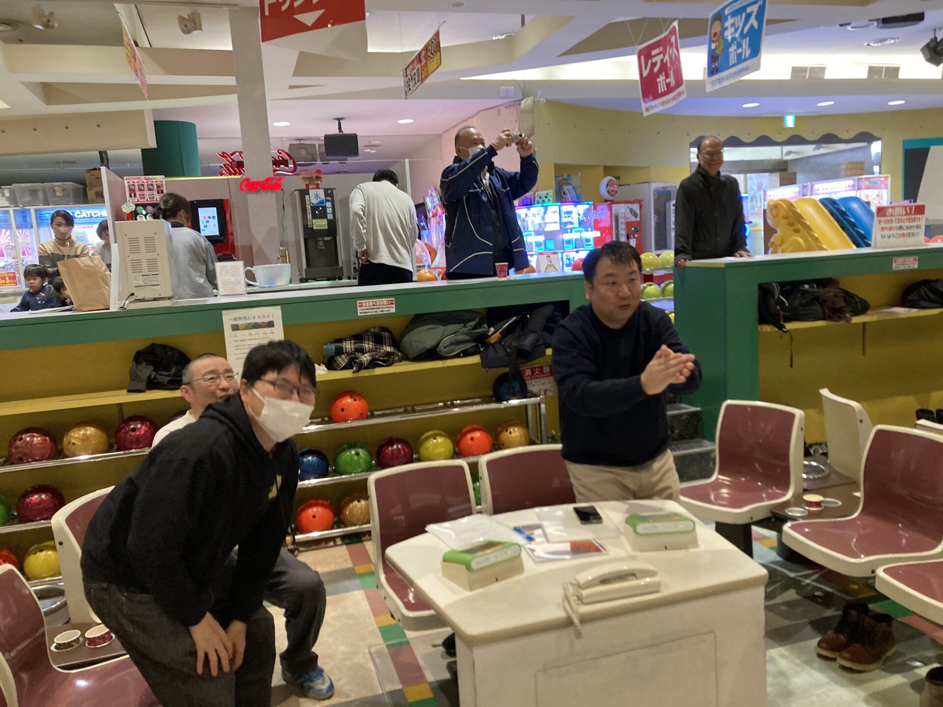 ボウリングで盛り上がる男性3人